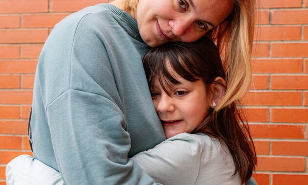 blonde woman and young girl hugging