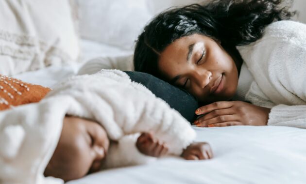 african american mom laying in bed with baby