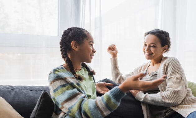young female talking on couch with adult female