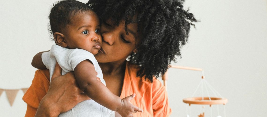 african american woman kissing baby